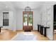 Inviting foyer features light hardwood floors, striking light fixture, and an attractive double-door entryway at 3933 Ayrshire Pl, Charlotte, NC 28210