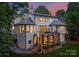 Lush backyard showing the house's stone columned covered patio, second story deck, and garden space at 3933 Ayrshire Pl, Charlotte, NC 28210