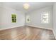 Spacious bedroom featuring hardwood floors, three large windows, and neutral paint palette at 4021 Nettie Ct # 7, Charlotte, NC 28211