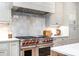 Kitchen showing a stainless steel range with white tile backsplash and white cabinets at 4021 Nettie Ct # 7, Charlotte, NC 28211