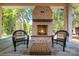 Covered outdoor patio with brick fireplace, wicker chairs, and scenic view of the surrounding landscape at 4021 Nettie Ct # 7, Charlotte, NC 28211