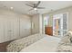 Bedroom featuring three closets, modern ceiling fan, and windows at 520 Sedgefield Park Dr, Charlotte, NC 28203