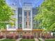 Modern townhouse exterior with brick facade, gray siding and orange accents offer an attractive curb appeal at 520 Sedgefield Park Dr, Charlotte, NC 28203
