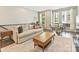 Cozy living room featuring hardwood floors, a neutral sofa, and a bright workspace near the windows at 520 Sedgefield Park Dr, Charlotte, NC 28203
