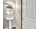 Well-lit half bathroom with a pedestal sink and white door at 5206 Fire Water Ln, Fort Mill, SC 29707
