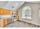 Bright kitchen featuring stainless steel appliances, wood cabinets, and an arched window at 5206 Fire Water Ln, Fort Mill, SC 29707