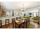 A dining room features a chandelier, wooden table set for six, and open floor plan to kitchen and living room at 79115 Ridgehaven Rd, Lancaster, SC 29720