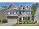 Charming two-story home featuring a stone facade, dormer windows, a two-car garage, and beautifully landscaped front yard at 79115 Ridgehaven Rd, Lancaster, SC 29720