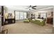 Spacious living room with a ceiling fan, many windows, a cabinet and comfortable green seating at 79115 Ridgehaven Rd, Lancaster, SC 29720
