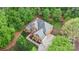 Aerial view of a two story brick home surrounded by mature trees and green space at 8032 Turnberry Ln, Stanley, NC 28164