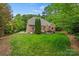 Well-manicured lawn featuring a brick home with a stone patio perfect for entertaining and relaxation at 8032 Turnberry Ln, Stanley, NC 28164