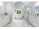 Bright bathroom with marble floors, soaking tub, glass shower, and double vanity at 8032 Turnberry Ln, Stanley, NC 28164