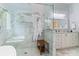 Bright bathroom featuring a glass enclosed shower, marble tile, and and vanity at 8032 Turnberry Ln, Stanley, NC 28164