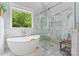 Bright bathroom featuring a soaking tub, walk in shower, and marble detailing at 8032 Turnberry Ln, Stanley, NC 28164