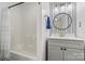 This bathroom features a gray vanity, a black and white patterned wall, and a tub with a white shower curtain at 8032 Turnberry Ln, Stanley, NC 28164
