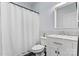 This bathroom features a white shower curtain, toilet and vanity with a marble countertop and modern fixtures at 8032 Turnberry Ln, Stanley, NC 28164