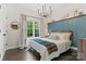 Cozy bedroom with an accent wall, hardwood floors, and stylish lighting at 8032 Turnberry Ln, Stanley, NC 28164
