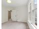A bright bedroom featuring large windows, neutral carpet, white walls, white trim, and an open doorway at 8032 Turnberry Ln, Stanley, NC 28164