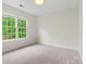 A bright bedroom featuring a large window, neutral carpet, and white walls at 8032 Turnberry Ln, Stanley, NC 28164