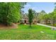 Charming brick home with a meticulously maintained lawn and mature trees at 8032 Turnberry Ln, Stanley, NC 28164
