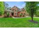 Inviting two-story brick home featuring a lush lawn and manicured landscaping at 8032 Turnberry Ln, Stanley, NC 28164