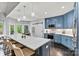 Open concept kitchen with blue cabinets, marble countertops, stainless appliances, and eat-in counter at 8032 Turnberry Ln, Stanley, NC 28164