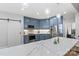 Bright kitchen features blue cabinets, stainless steel appliances, pendant lighting, and marble countertops at 8032 Turnberry Ln, Stanley, NC 28164