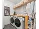 This laundry room features a side-by-side washer and dryer, lots of storage, and modern decor at 8032 Turnberry Ln, Stanley, NC 28164