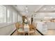 Bright dining room featuring a rustic table, white cabinets, tiled floor, and window shutters at 8326 Ramath Dr, Charlotte, NC 28211