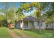 Quaint home with a charming exterior, set on a lush lawn under mature trees, with a long driveway at 872 Wellman St, Gastonia, NC 28054