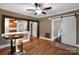 Bright living room featuring hardwood floors, a ceiling fan, and stylish barn doors opening to adjacent rooms at 872 Wellman St, Gastonia, NC 28054