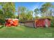 View of two outbuildings with painted wood, one with decorative accents and chain link fence at 872 Wellman St, Gastonia, NC 28054