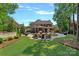 An expansive backyard featuring a fire pit, outdoor kitchen, dining, and lounging areas at 1102 Anniston Pl, Wesley Chapel, NC 28079