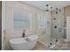 A spa-like bathroom featuring a soaking tub and a glass-enclosed shower offers relaxation and luxury at 1102 Anniston Pl, Wesley Chapel, NC 28079