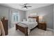 Inviting bedroom with a wooden frame bed, neutral color palette, and soft lighting for a relaxing retreat at 1102 Anniston Pl, Wesley Chapel, NC 28079