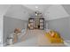 Open bonus room with fun seating, storage, and a sliding door to another room, perfect for a playroom or den at 1102 Anniston Pl, Wesley Chapel, NC 28079