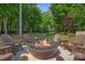 A backyard fire pit featuring Adirondack chairs and a lush green lawn at 1102 Anniston Pl, Wesley Chapel, NC 28079