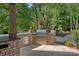 An outdoor kitchen featuring a built-in grill, stainless steel drawers, and a stone countertop at 1102 Anniston Pl, Wesley Chapel, NC 28079