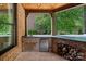 This is a covered outdoor kitchen featuring brick walls, stone floors, and a mini fridge at 1102 Anniston Pl, Wesley Chapel, NC 28079