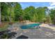 An inviting in-ground pool with a slide, tanning ledge and spa is surrounded by mature trees at 1102 Anniston Pl, Wesley Chapel, NC 28079