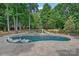 Beautiful in-ground pool surrounded by lush landscaping, featuring a slide and spa at 1102 Anniston Pl, Wesley Chapel, NC 28079
