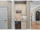 The custom wine bar showcases a wine fridge and storage, creating a perfect spot for entertaining guests at 1102 Anniston Pl, Wesley Chapel, NC 28079