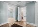 Hallway featuring hardwood flooring and light blue walls connecting various rooms in the home at 127 Bristol Rd, Statesville, NC 28677