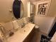Updated bathroom with a large vanity, decorative mirror, built-in shelving and wainscoting at 127 Hummingbird Cir, New London, NC 28127