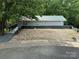 Quaint home with gray metal roof and wood planked landscaping retaining wall at 127 Hummingbird Cir, New London, NC 28127