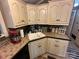 Kitchen with neutral cabinets, decorative backsplash, and corner sink at 127 Hummingbird Cir, New London, NC 28127