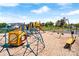 Colorful playground equipment including swings, slides, and climbing structures in a sand-filled area at 127 Hummingbird Cir, New London, NC 28127