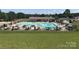 Community pool surrounded by lounge chairs, umbrellas, and a lush lawn at 127 Hummingbird Cir, New London, NC 28127