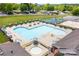 Large community pool with ample seating, umbrellas, and a basketball court, providing recreational opportunities at 127 Hummingbird Cir, New London, NC 28127