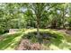 Overhead view of the backyard featuring a manicured lawn, storage sheds, and mature trees at 1468 Woodhurst Dr, Rock Hill, SC 29732